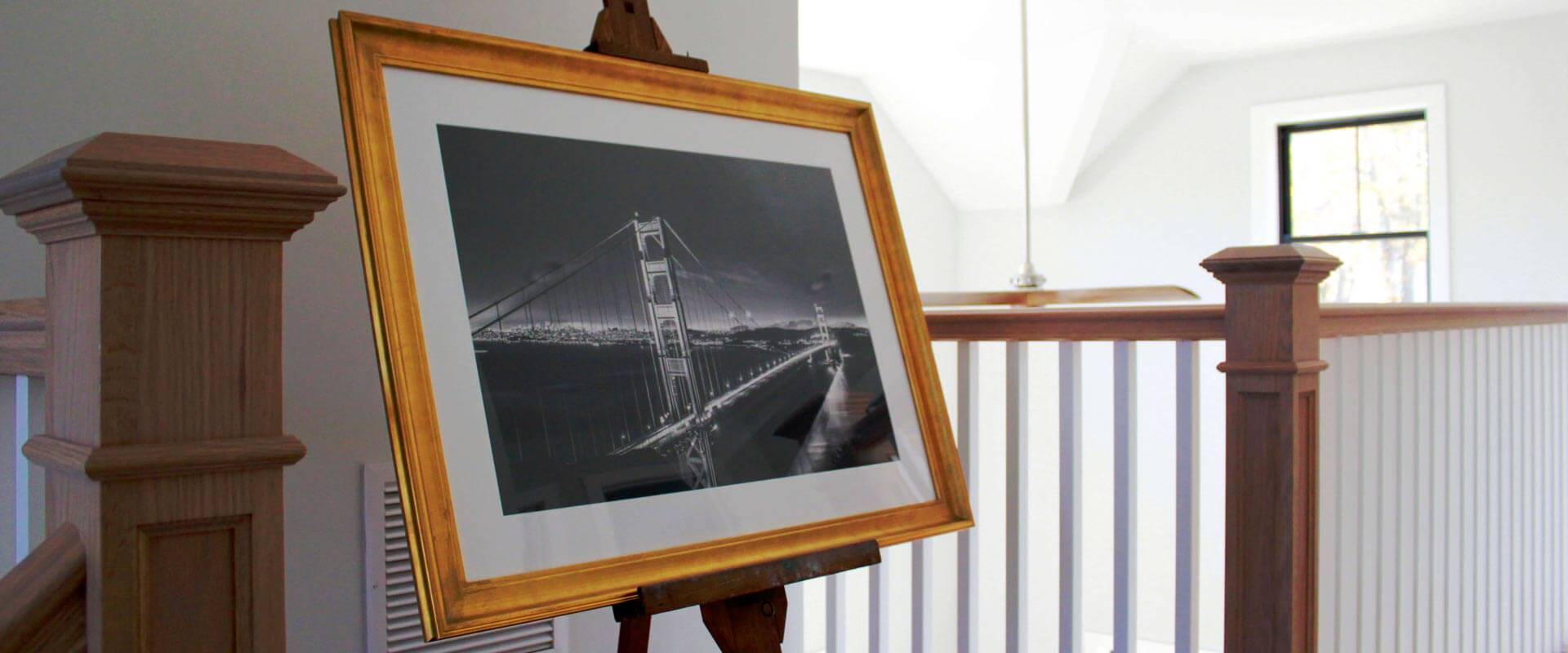 An easel with a photograph on a stair landing.
